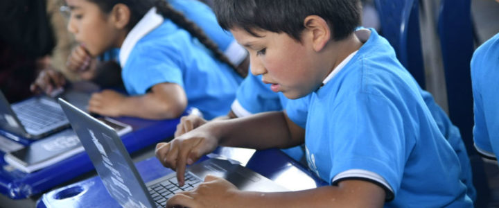 Estudiantes en clase usando computadores